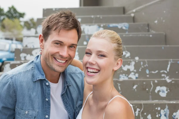 Couple assis sur les marches souriant — Photo