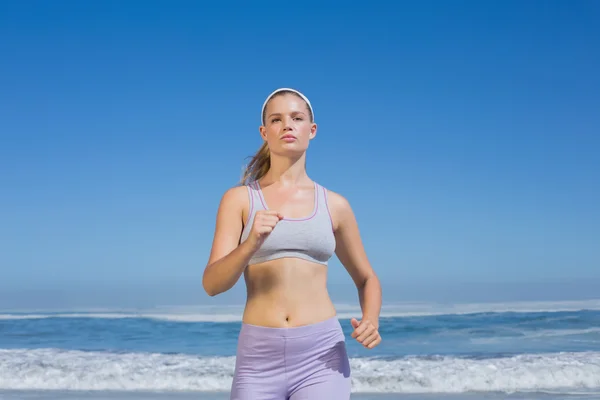 Sportowy koncentruje się blondynka jogging na plaży — Zdjęcie stockowe