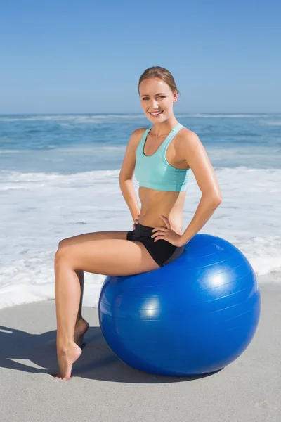 Kobieta siedzi na ćwiczenia piłka na plaży — Zdjęcie stockowe