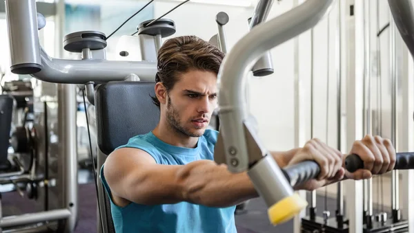 Man using weights machine for arms — Stock Photo, Image