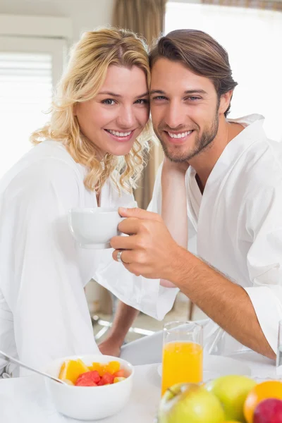 Casal em roupões de banho tomando café da manhã — Fotografia de Stock