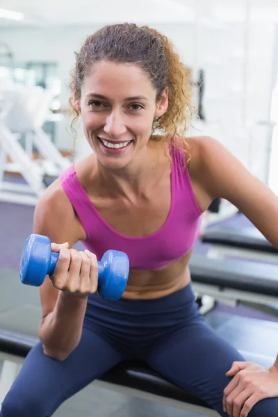 Kameraya gülümseyen oldukça uygun kadın dumbbell mavi kaldırma — Stok fotoğraf