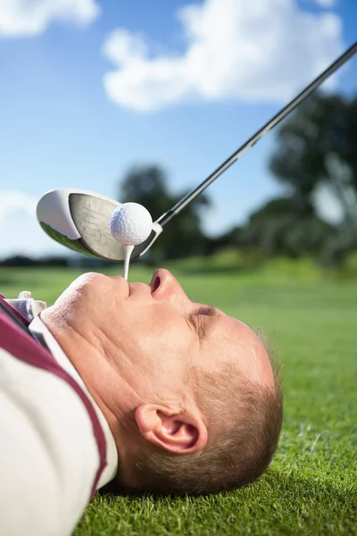 Golfspelare anläggning tee i hans tänder — Stockfoto