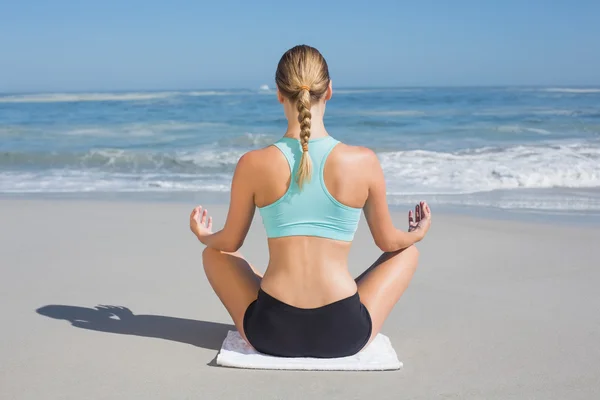 Fit woman on beach in lotus pose — Stock Photo, Image
