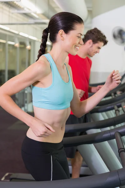 Couple running together on treadmills — Stock Photo, Image