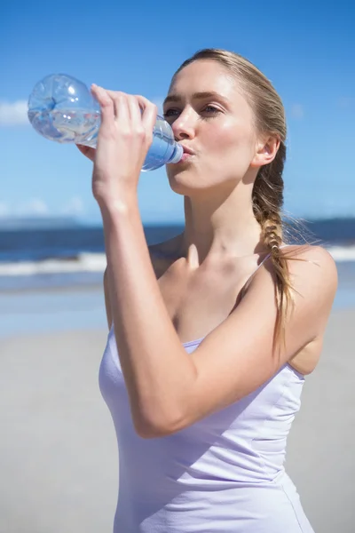 Blonde drinkwater op het strand — Stockfoto