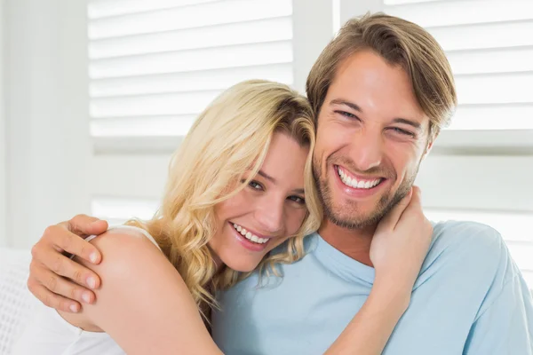 Casal sentado no sofá rindo — Fotografia de Stock