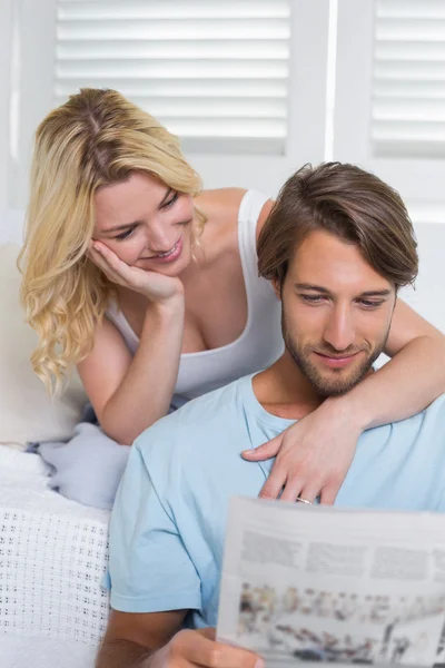 Pareja en el sofá leyendo el periódico — Foto de Stock