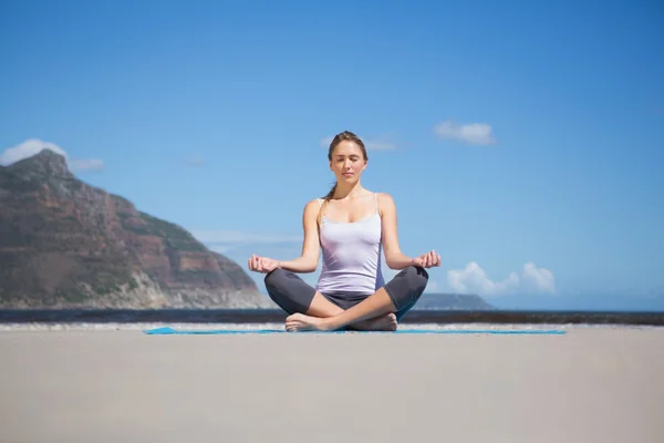 Kumsalda yoga yaparken sarışın — Stok fotoğraf