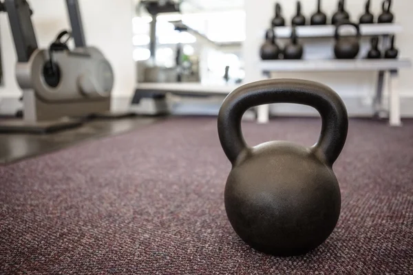 Black kettlebell on the weights room floor — Stock Photo, Image