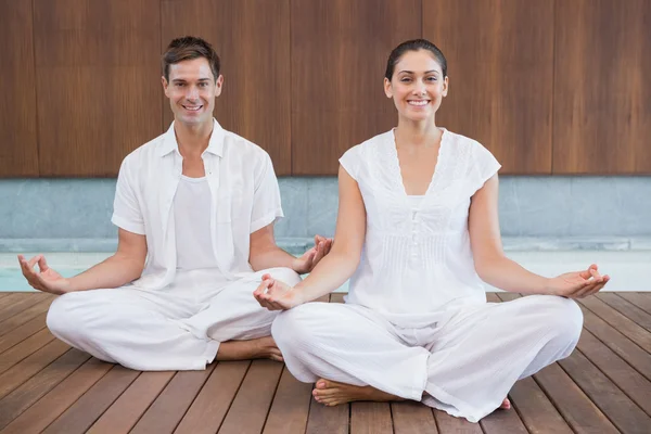 Couple en blanc assis dans la pose du lotus — Photo