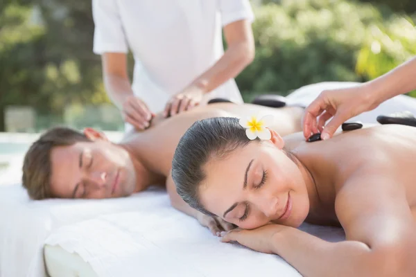 Couple enjoying hot stone massage — Stock Photo, Image