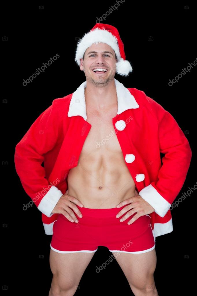 Homme musculaire posant en tenue de Père Noël image libre de droit par