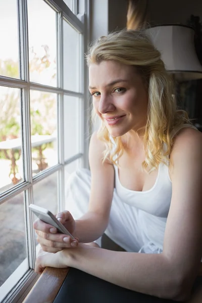 Rubia por ventana enviando texto — Foto de Stock