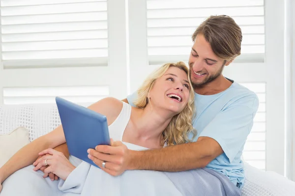 Casal no sofá usando tablet — Fotografia de Stock