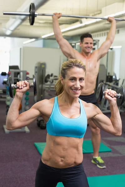 Homem muscular feliz e mulher levantando pesos — Fotografia de Stock