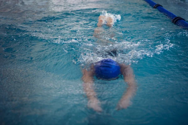 Подходящая женщина, плавающая в бассейне — стоковое фото