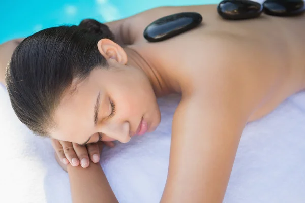 Brünette mit ein heiß stein massage — Stockfoto