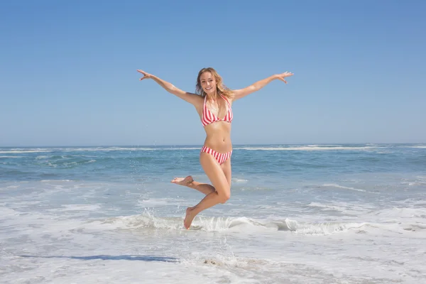 Mulher de biquíni pulando na praia — Fotografia de Stock