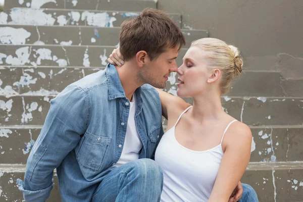 Couple sitting on steps showing affection — Stock Photo, Image
