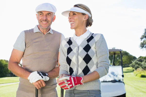 Pareja de golf con buggy de golf detrás — Foto de Stock