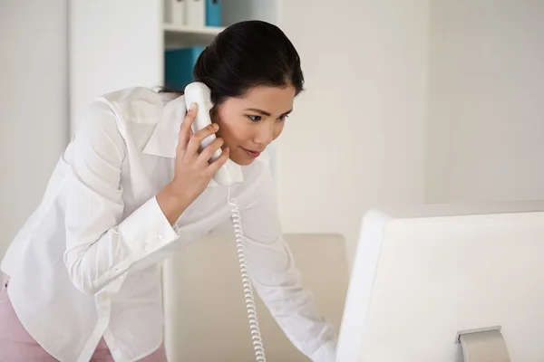 Businesswoman answering the telephone — Stock Photo, Image