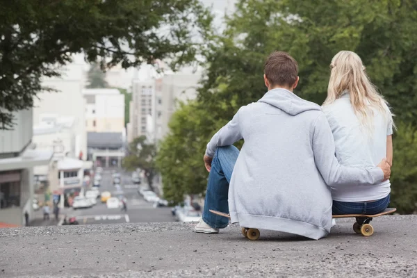 Couple sitting on skateboard — Stock Photo, Image