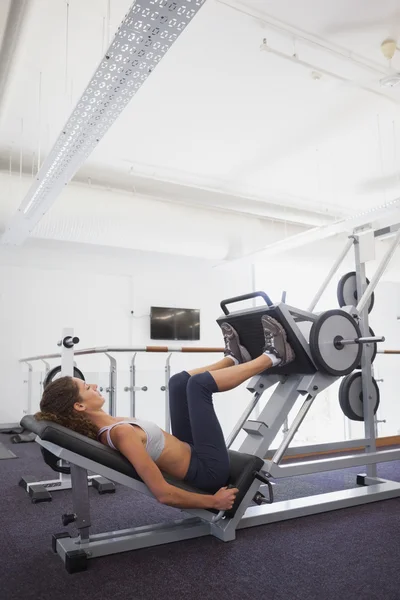 Femme utilisant la machine de poids pour les jambes — Photo