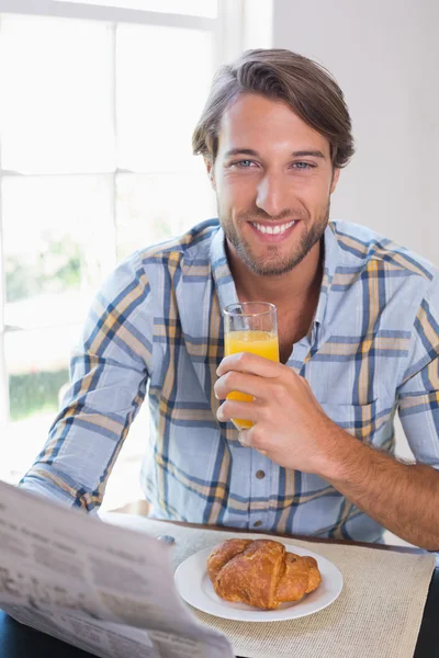 Улыбающийся мужчина с апельсиновым соком — стоковое фото