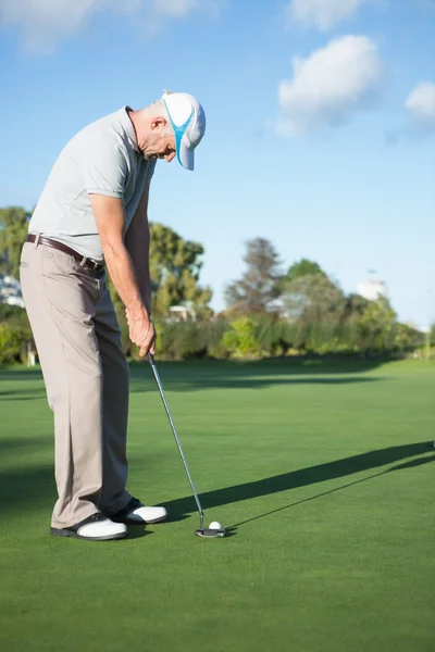 Schöner Golfer beim Putten des Balls auf dem Grün — Stockfoto