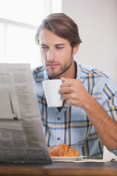 Man drinking coffee and reading newspaper — Stock Photo, Image