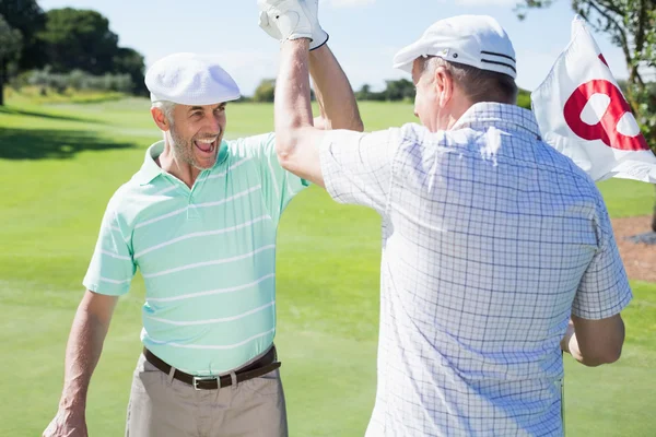 Golf vänner hög fiving på artonde hålet — Stockfoto