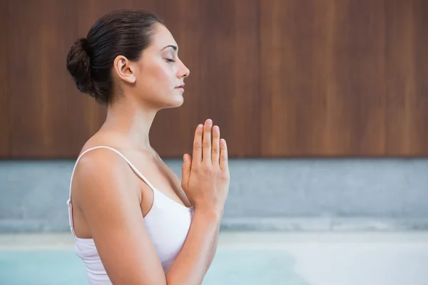 Brunette in white sitting in lotus pose — Stock Photo, Image