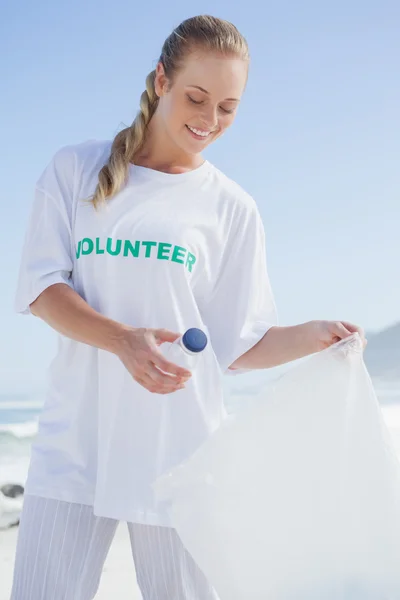 Волонтёр собирает мусор на пляже — стоковое фото