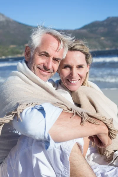 Paret sitter på stranden under filt — Stockfoto