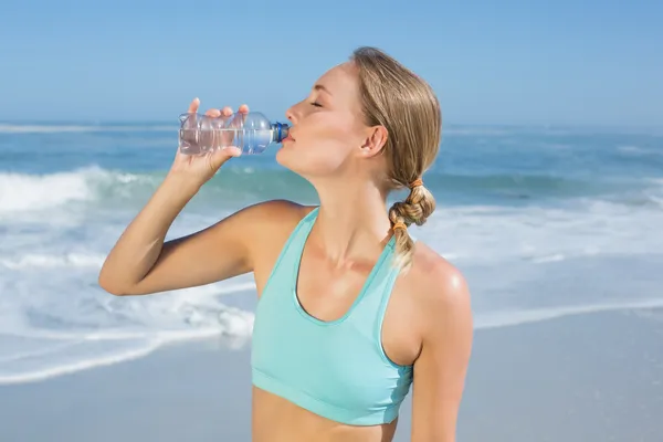 Fit woman on beach taking a drink — Stock Photo, Image