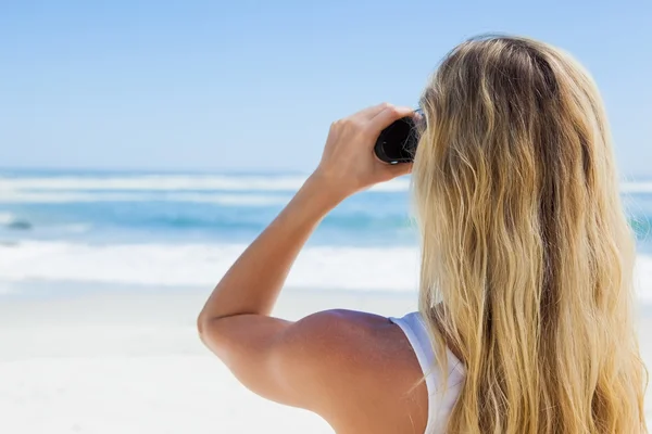 Blonde op zoek door middel van verrekijkers — Stockfoto