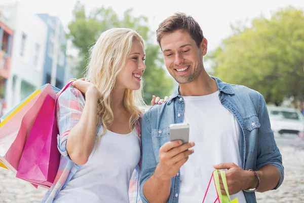 Casal olhando para smartphone em viagem de compras — Fotografia de Stock