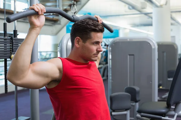 Bodybuilder using weight machine — Stock Photo, Image