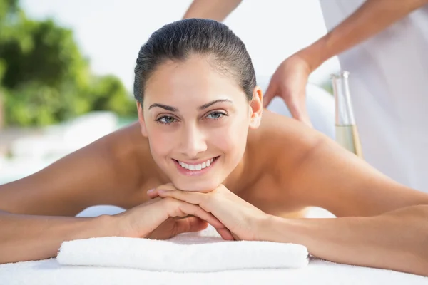 Morena disfrutando de un masaje junto a la piscina — Foto de Stock