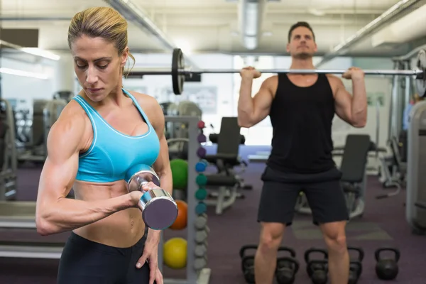 Muscular man and woman lifting weights — Stock Photo, Image