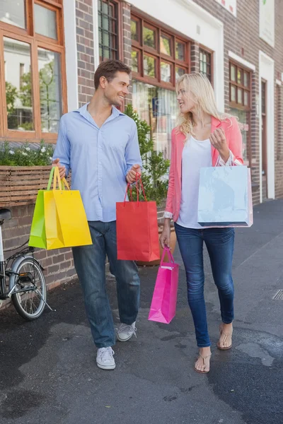 Stijlvolle paar wandelen met shopping tassen — Stockfoto