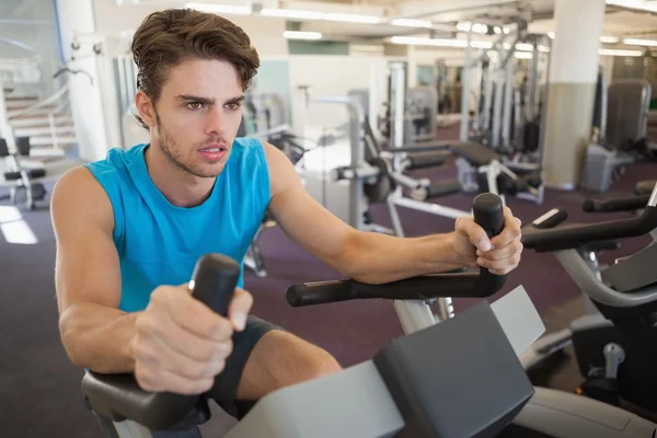 Homme de forme concentré sur le vélo d'appartement — Photo