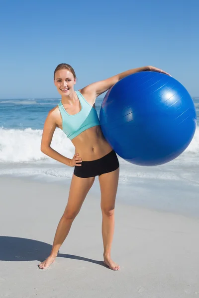 Woman on beach holding exercise ball — Stock Photo, Image