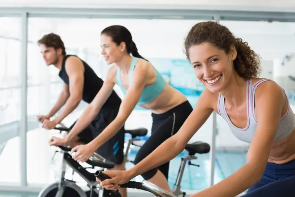 Encaixe pessoas em uma aula de spin com a mulher — Fotografia de Stock