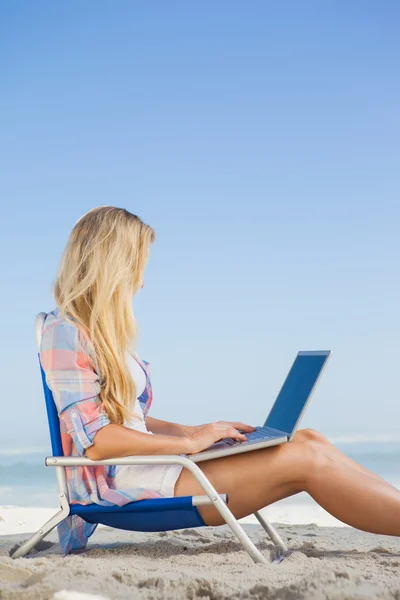 Blondine am Strand mit Laptop — Stockfoto