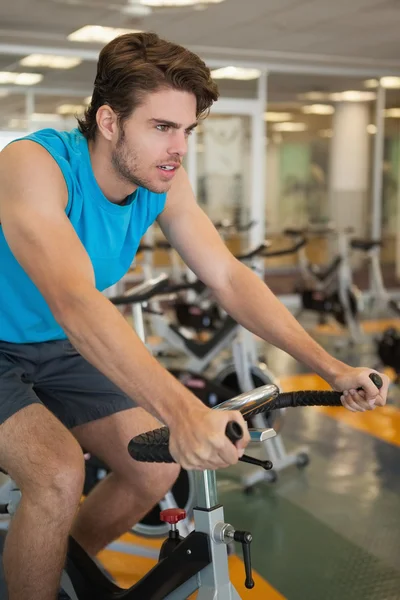Uomo in forma focalizzata sulla spin bike — Foto Stock