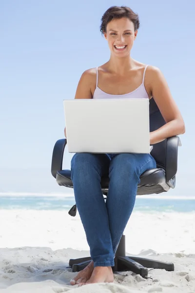 Brunett med laptop på stranden — Stockfoto