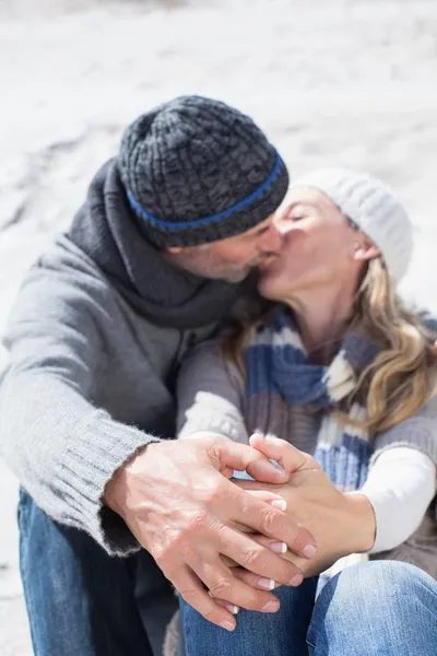 Paar zoenen op het strand in warme kleding — Stockfoto