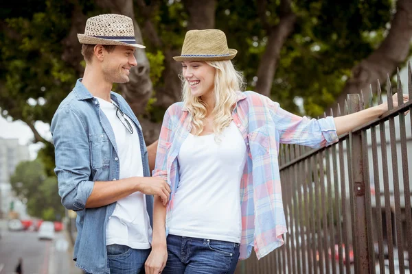 Hip couple standing by railings — Stock Photo, Image